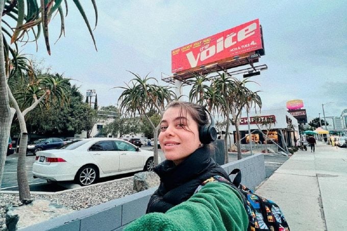 Дария Гроссман (DASHA) на фоне афиши The Voice