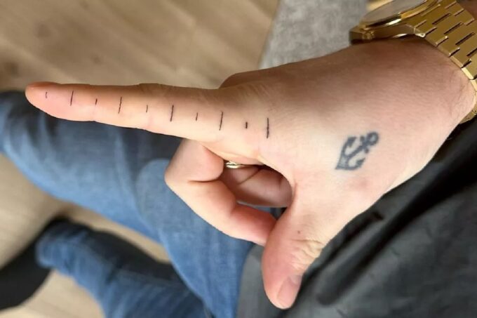 Татуировка Штеффена Карлсена с линейкой на пальце